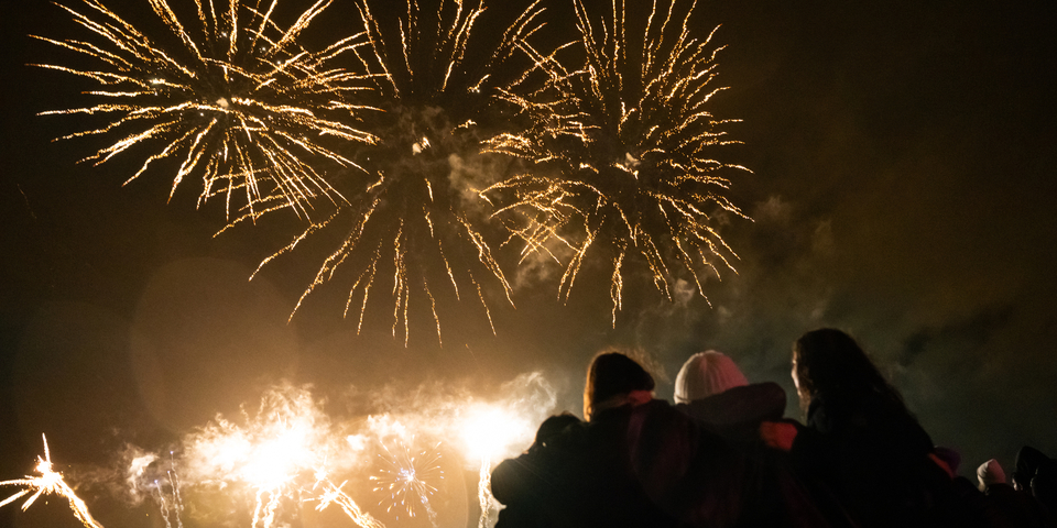 Meisjes kijken arm in arm naar het vuurwerk